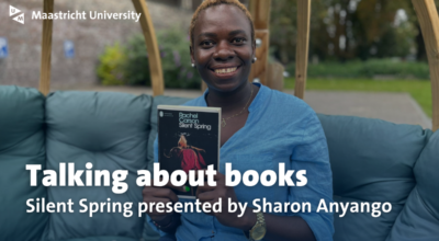woman in garden who holds up a book