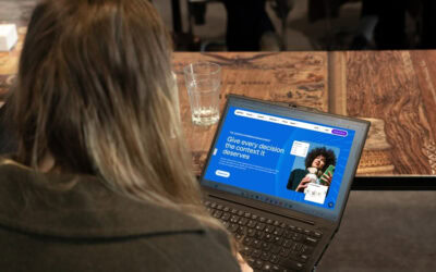 a girl watching a laptop screen with a Qualtrics homepage on it