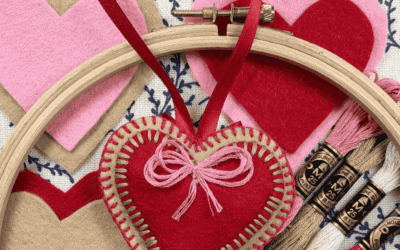Heart-shaped felt ornaments and embroidery hoops with Valentine's Day craft supplies.
