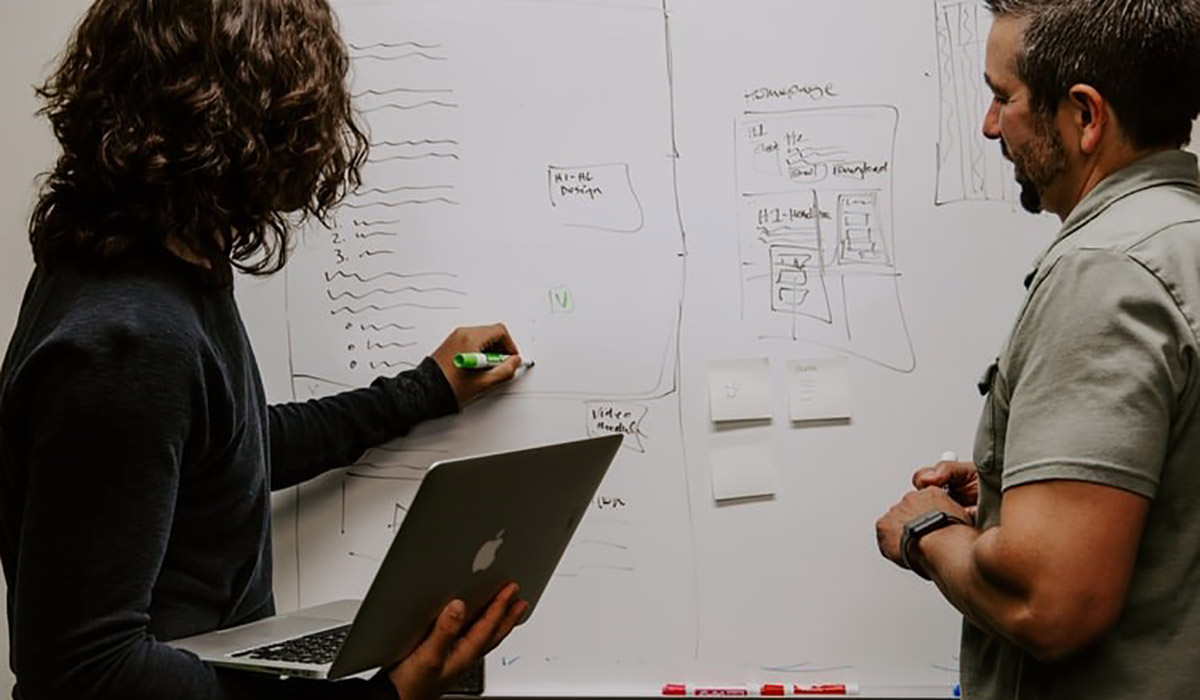 Two students writing on a whiteboard