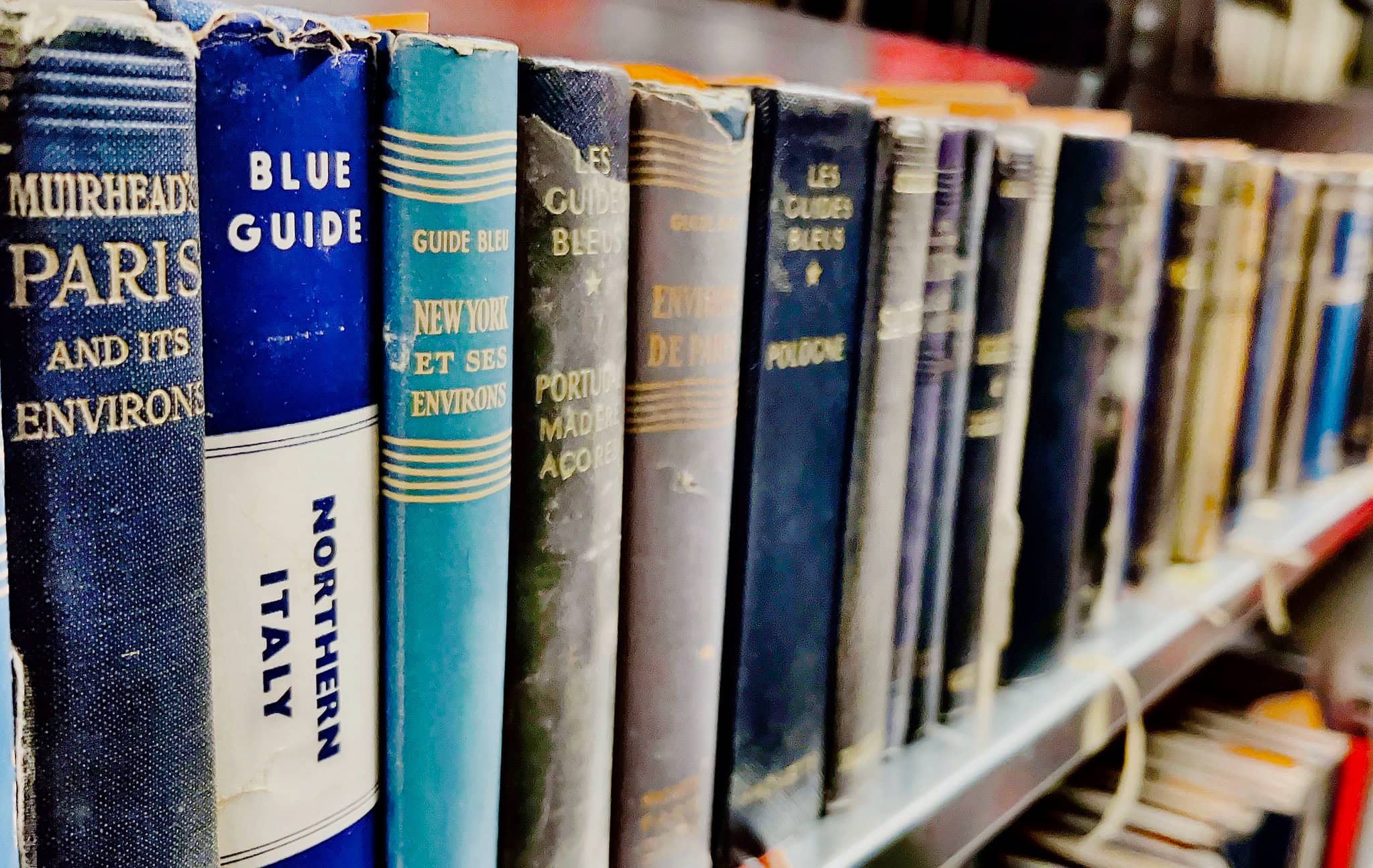 Bookshelves with travel and guidebooks at Maastricht University Library.