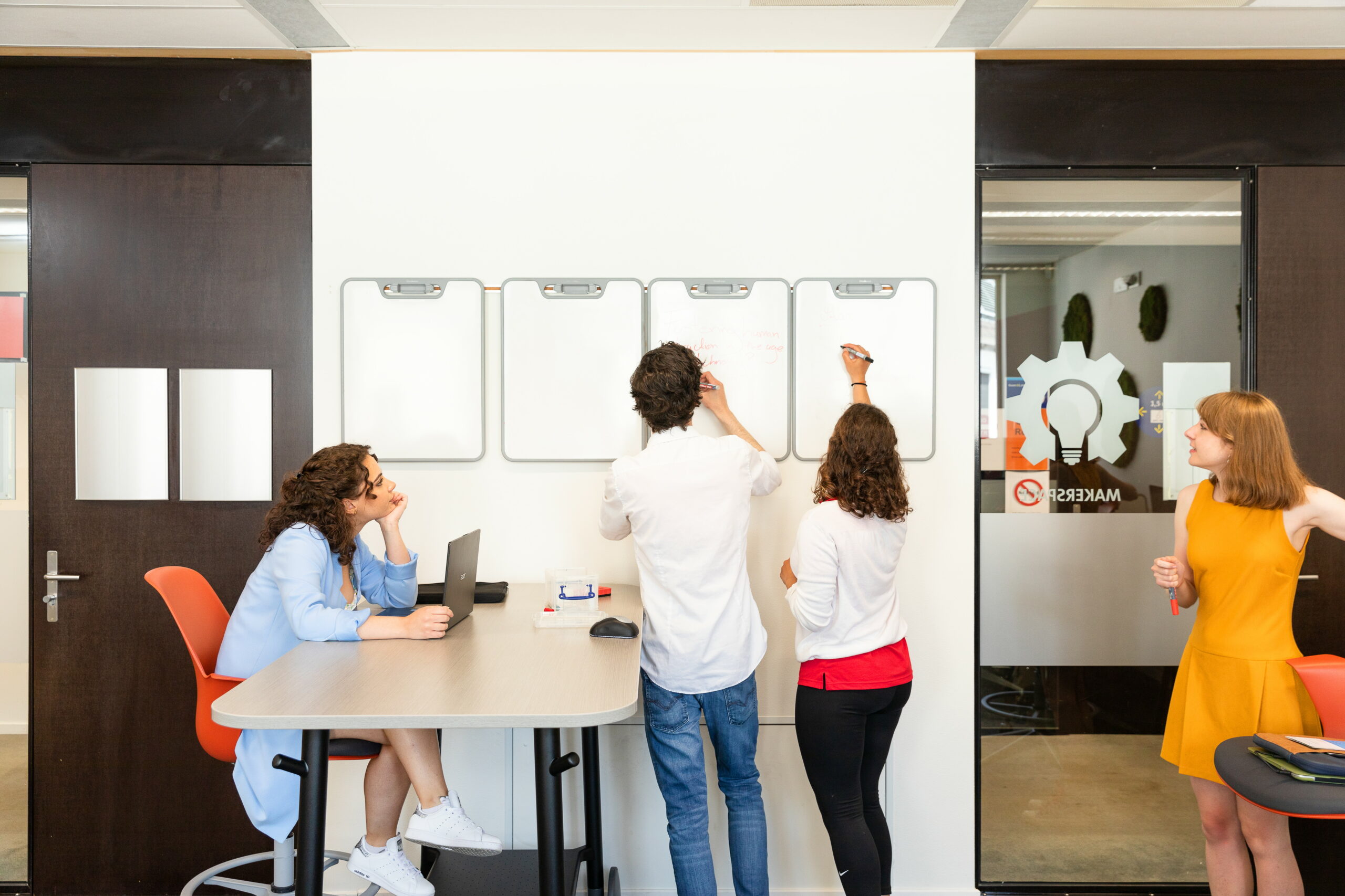 Students writing on whiteboards in the Makerspace