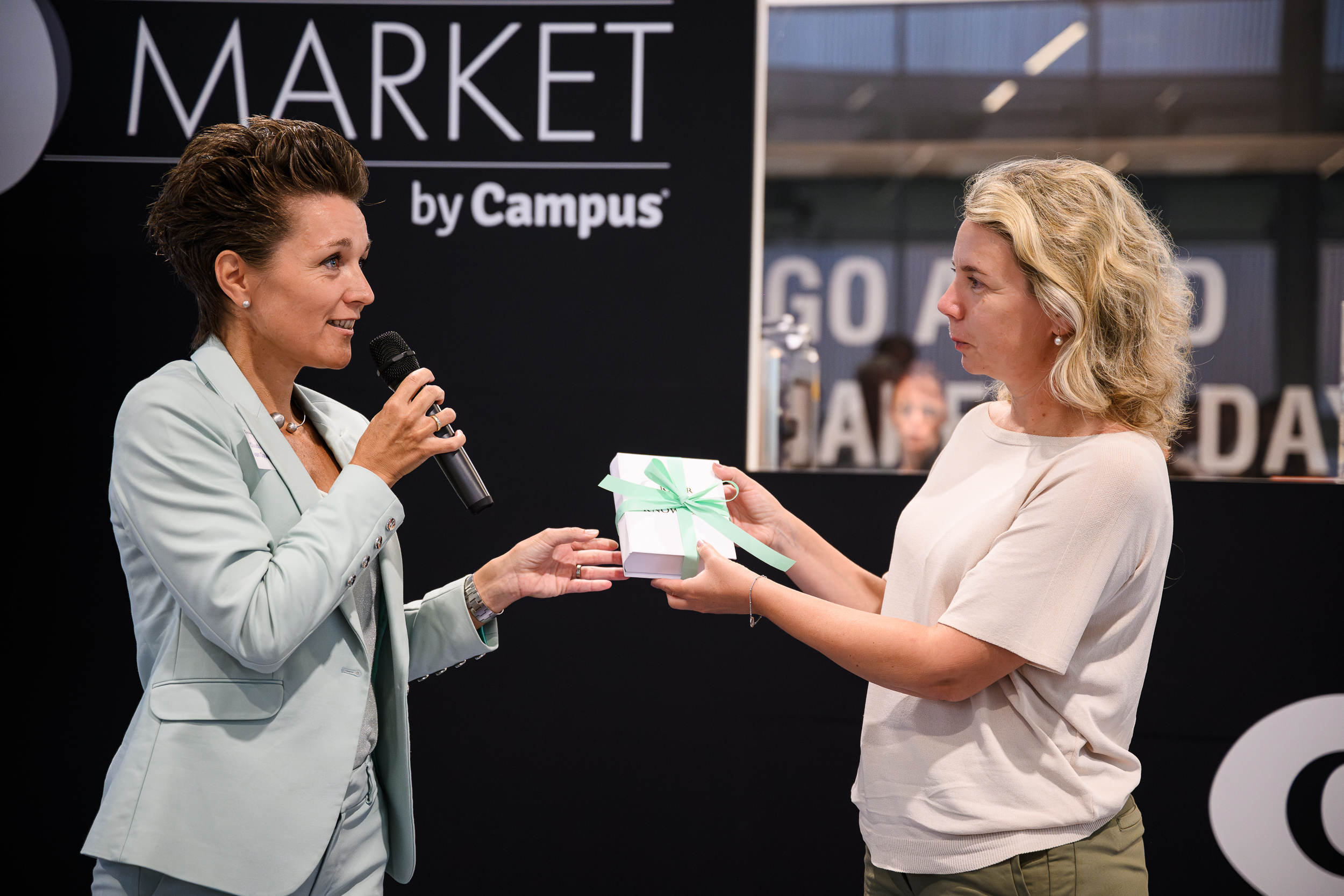 one woman hands book over to another woman