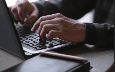 Hands typing on a laptop keyboard during work or study.