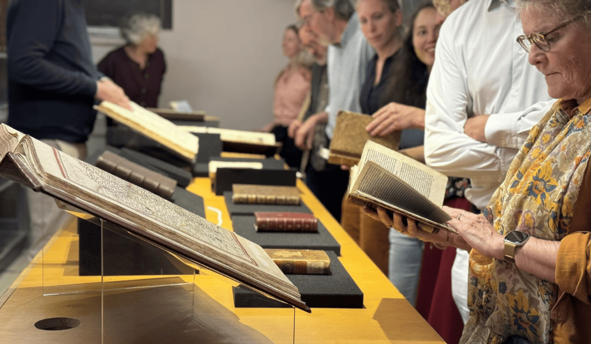 People exploring books at Maastricht University Library exhibit.
