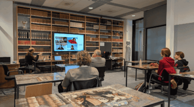 Online study session at Maastricht University Library with students and a digital instructor display.