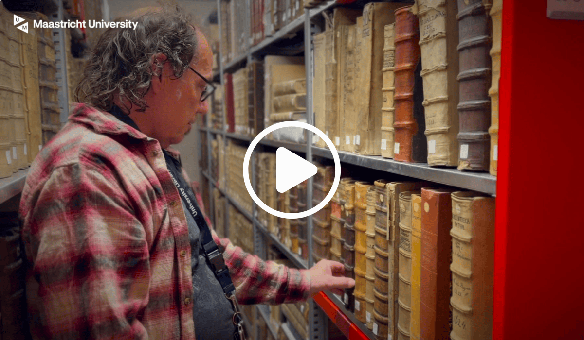 Ancient books on library shelves at Maastricht University Library for heritage preservation.