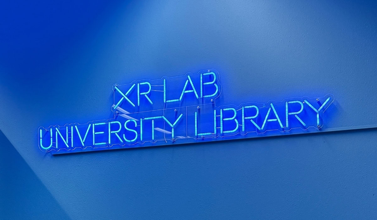 XRLAB University Library neon sign on blue wall.