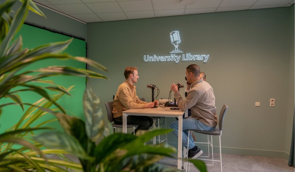 Maastricht University Library podcast recording with two men at a table.
