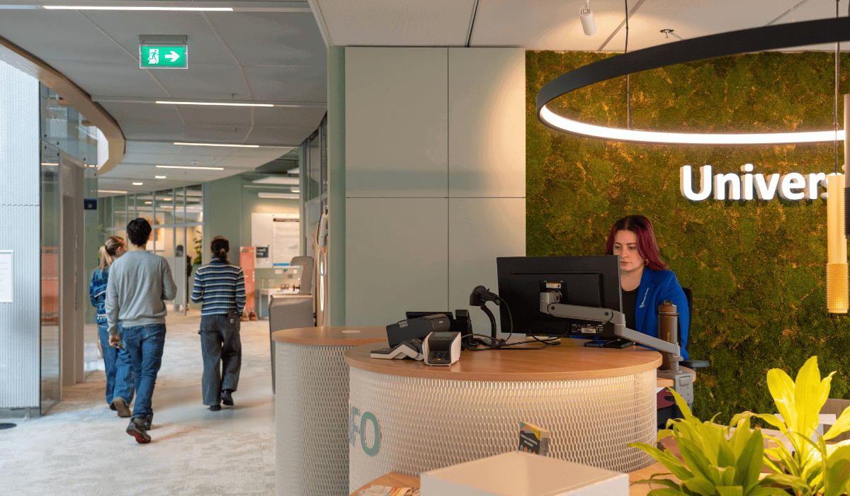 University library reception with staff and visitors in a modern setting.