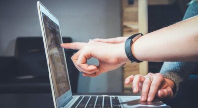 two people discussing in front of laptop
