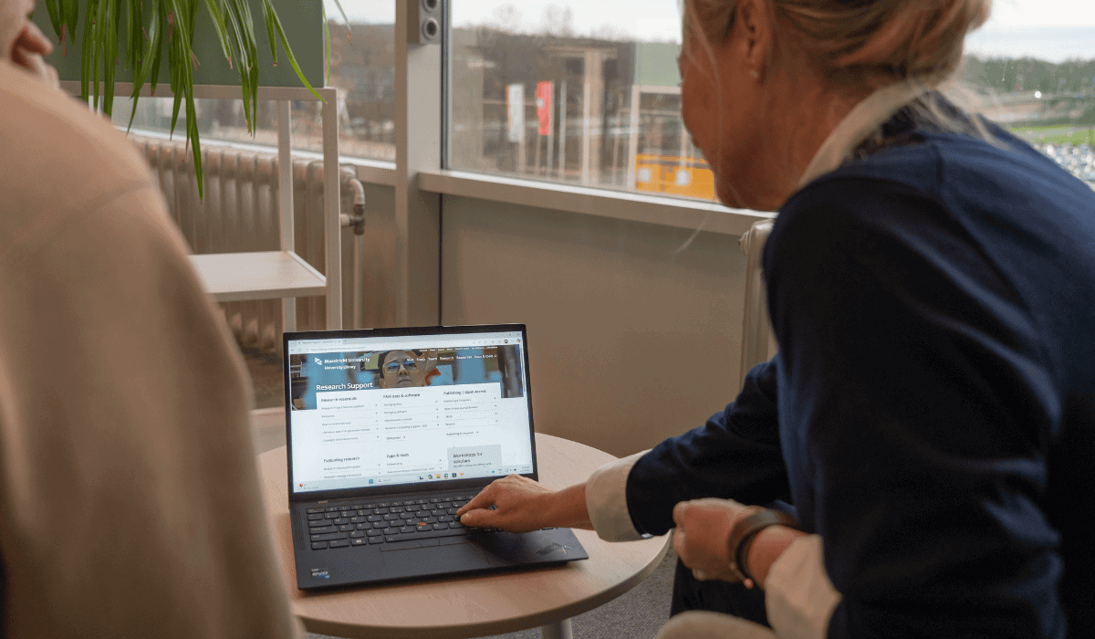 Student using a laptop at Maastricht University Library study area.